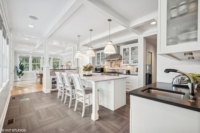 kitchen featuring range, a kitchen island, white cabinets, pendant lighting, and backsplash