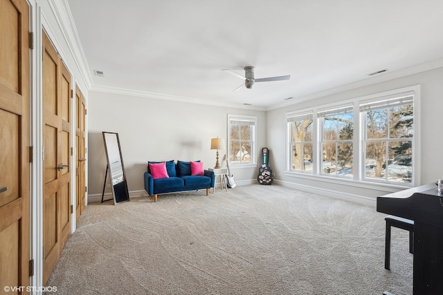 living area with crown molding, light colored carpet, and ceiling fan