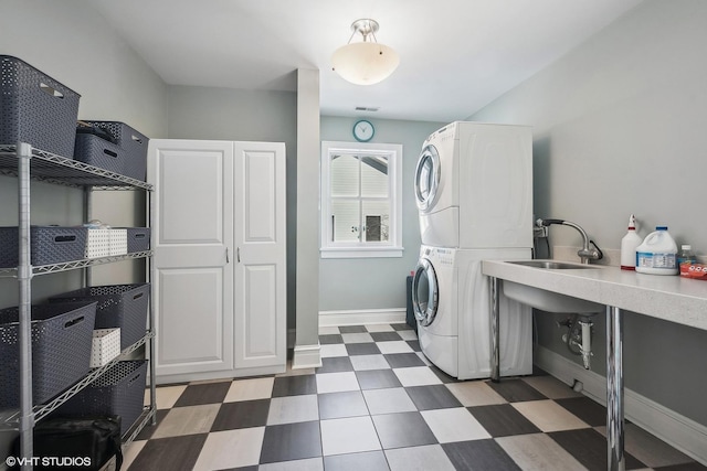 laundry room featuring stacked washing maching and dryer and sink