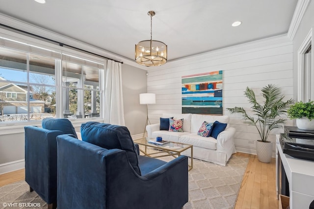 living room with ornamental molding, light hardwood / wood-style floors, and a chandelier