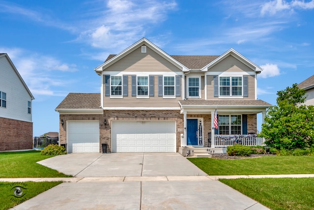 view of front of property featuring a garage, a front yard, and covered porch