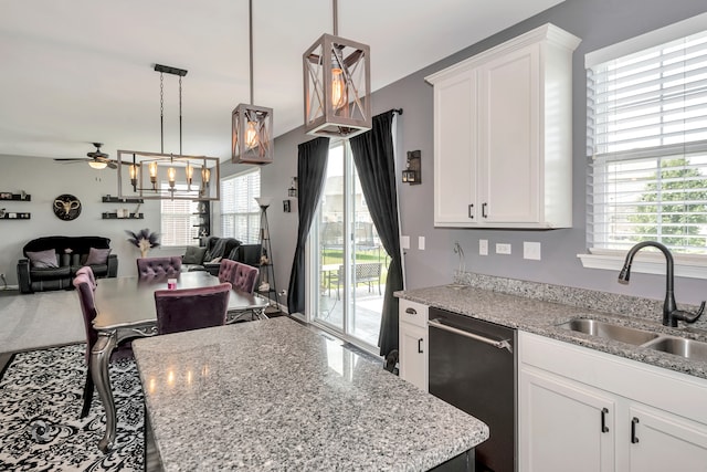 kitchen featuring white cabinets, stainless steel dishwasher, and a healthy amount of sunlight