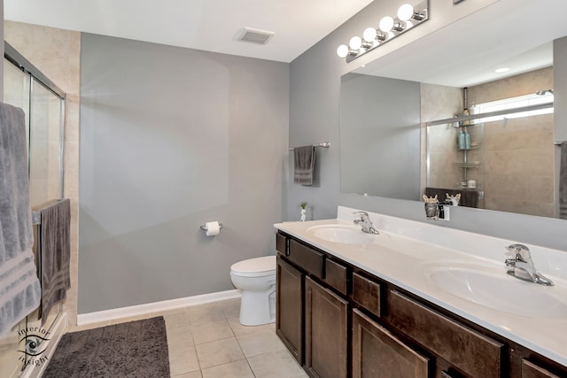 bathroom with tile patterned floors, vanity, a shower with door, and toilet