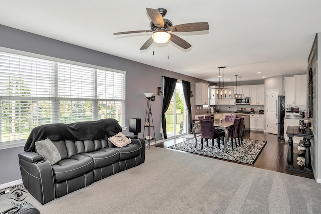 living room featuring dark hardwood / wood-style flooring, a wealth of natural light, and ceiling fan