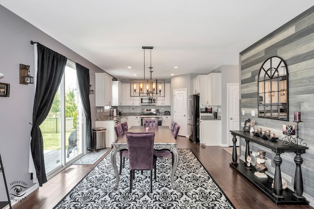 dining room with sink, a chandelier, and dark hardwood / wood-style floors