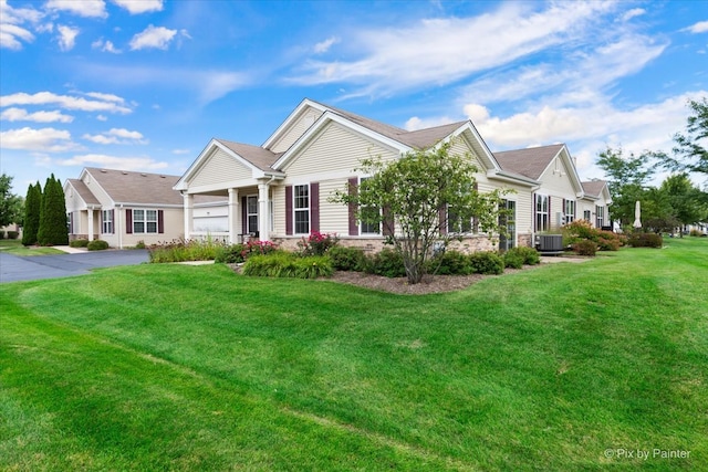 view of front of house featuring a front yard, a garage, and central air condition unit