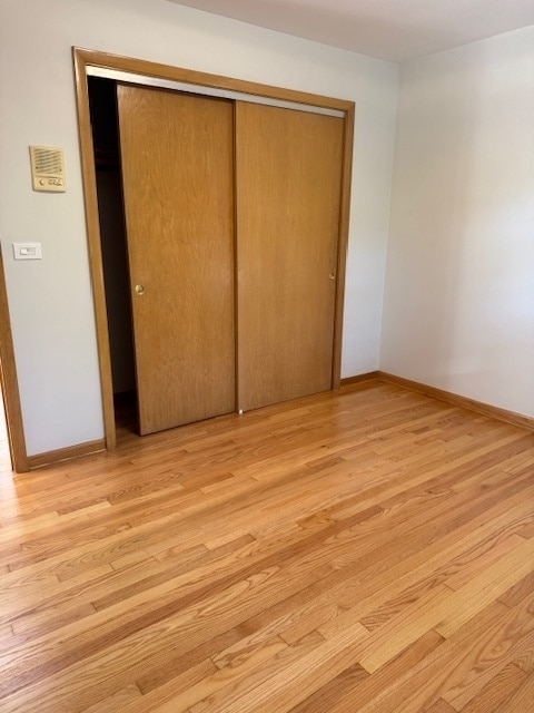 unfurnished bedroom featuring a closet and light wood-type flooring