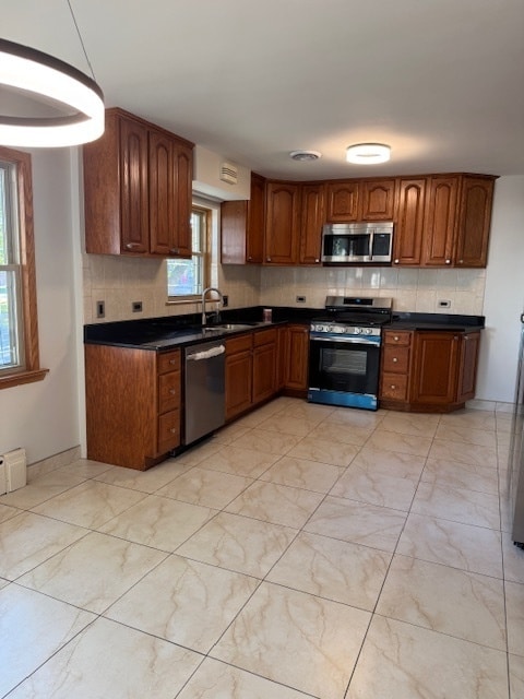 kitchen with tasteful backsplash, appliances with stainless steel finishes, and sink