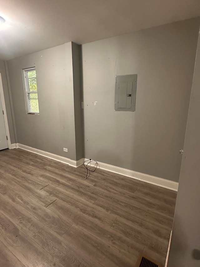 laundry area with electric panel and dark wood-type flooring