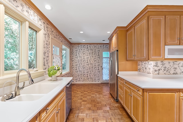 kitchen with stainless steel appliances, crown molding, sink, and light parquet floors