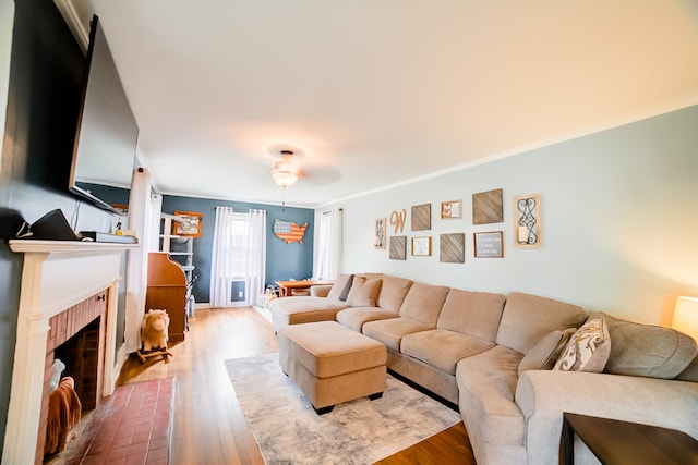 living room with wood-type flooring, a fireplace, and ceiling fan