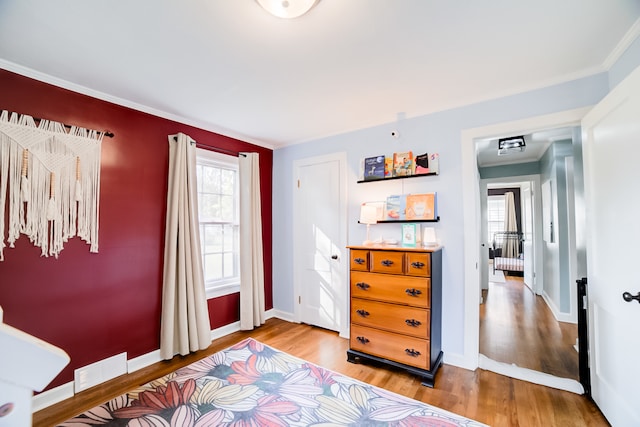 bedroom with ornamental molding and hardwood / wood-style flooring