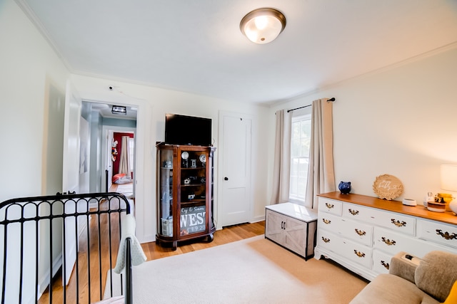 bedroom featuring crown molding and light hardwood / wood-style floors