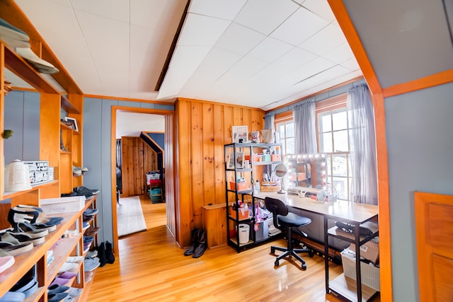 office area with wood walls and light hardwood / wood-style flooring