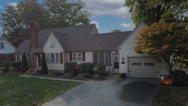 view of front of property featuring a front yard and a garage