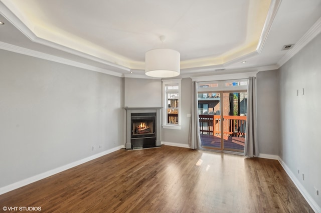 unfurnished living room with crown molding, wood-type flooring, and a raised ceiling