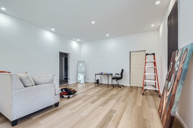 living room featuring a high ceiling and light wood-type flooring