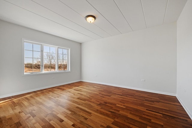 spare room with wood finished floors and baseboards