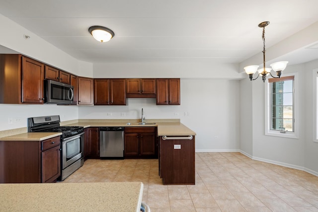 kitchen with a sink, light countertops, baseboards, and stainless steel appliances