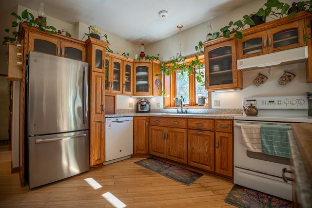 802 Union Rd, Harmon, IL 61042 - kitchen with white appliances, under cabinet range hood, brown cabinetry, light countertops, and a sink