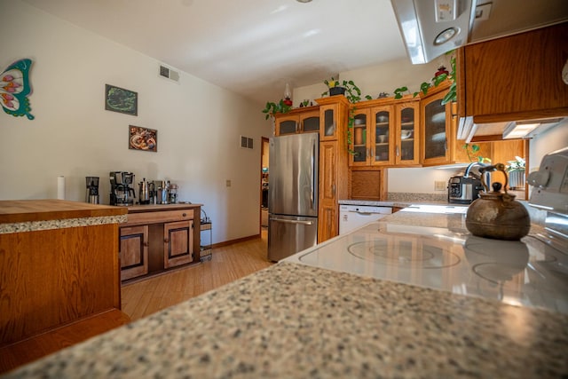 802 Union Rd, Harmon, IL 61042 - kitchen featuring freestanding refrigerator, brown cabinetry, light wood-style flooring, white dishwasher, and glass insert cabinets