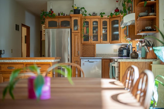 802 Union Rd, Harmon, IL 61042 - kitchen with dishwasher, freestanding refrigerator, brown cabinetry, light countertops, and glass insert cabinets