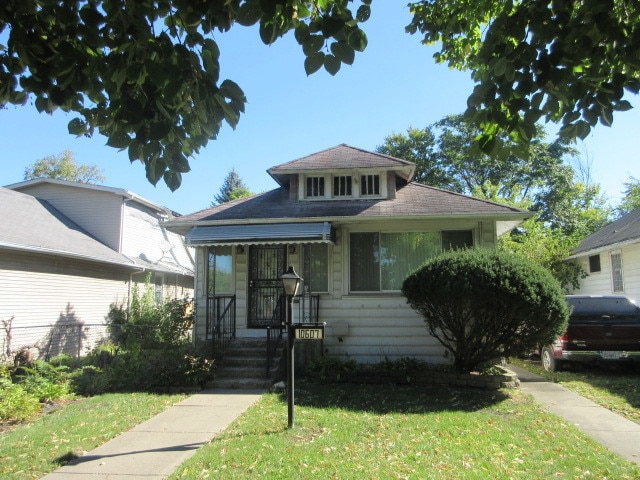 bungalow-style home with a front yard