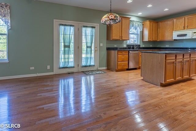 kitchen with decorative light fixtures, dishwasher, light wood-type flooring, and sink