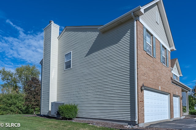 view of home's exterior with a garage and central air condition unit