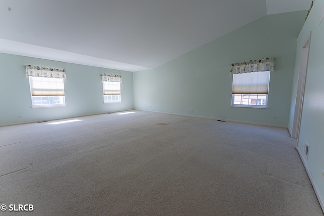 empty room with lofted ceiling and light carpet