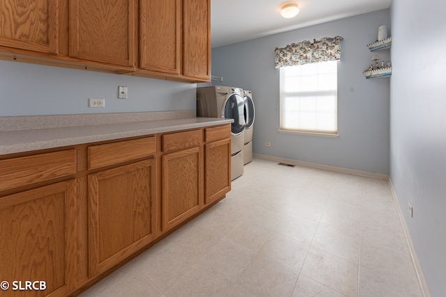 laundry area with washing machine and dryer and cabinets