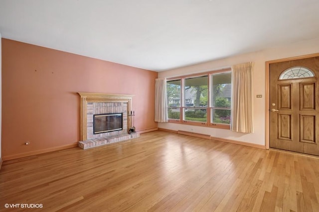 1087 Cedar Ln, Northbrook, IL 60062 - unfurnished living room with light wood finished floors, baseboards, a brick fireplace, and a baseboard heating unit