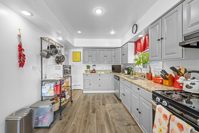 kitchen with sink, gray cabinets, stainless steel appliances, dark hardwood / wood-style floors, and a baseboard radiator