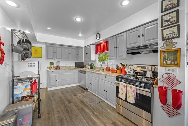 kitchen with gray cabinets, sink, light stone countertops, dark hardwood / wood-style floors, and appliances with stainless steel finishes