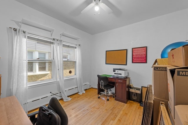 home office featuring ceiling fan, a baseboard radiator, and light hardwood / wood-style floors