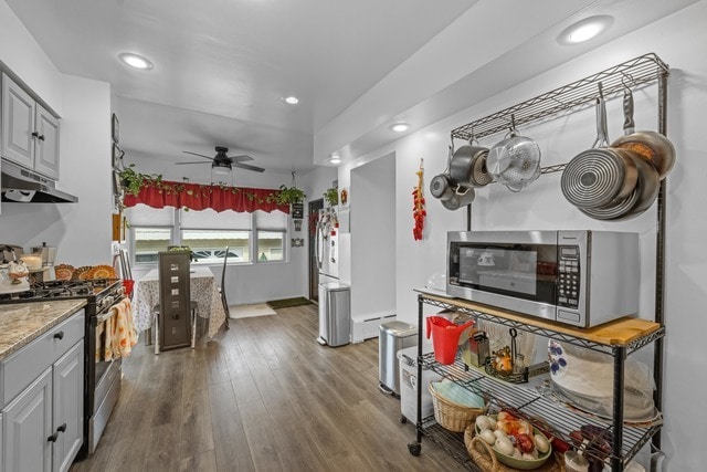 kitchen featuring ceiling fan, gray cabinetry, appliances with stainless steel finishes, a baseboard radiator, and dark hardwood / wood-style flooring