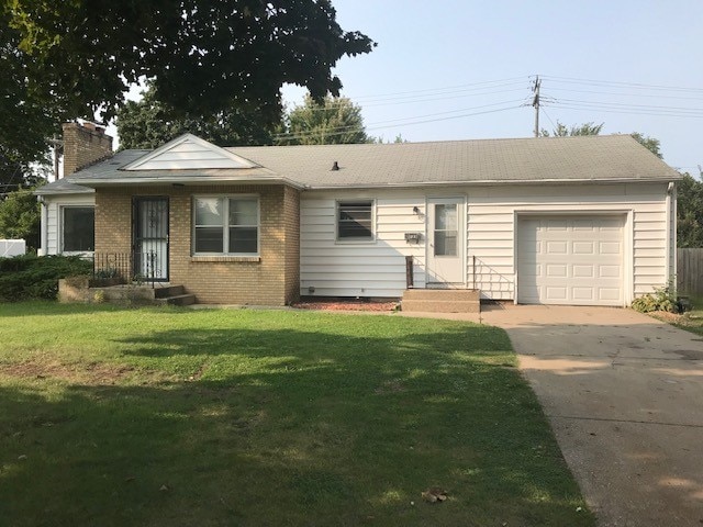 single story home featuring a front lawn and a garage