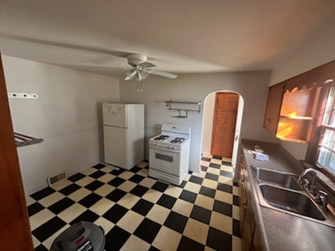 kitchen featuring ceiling fan, sink, and white appliances