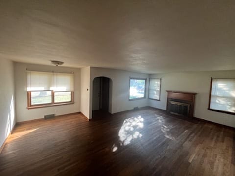 unfurnished living room with dark hardwood / wood-style floors