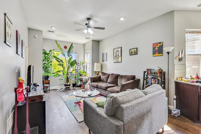 living room featuring ceiling fan and dark hardwood / wood-style flooring