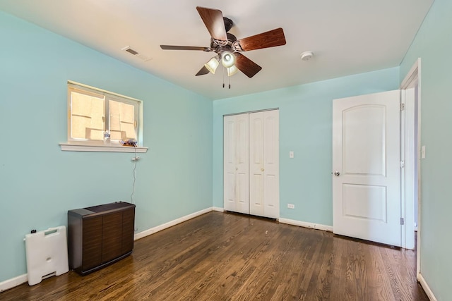 unfurnished bedroom with a closet, ceiling fan, and dark hardwood / wood-style flooring