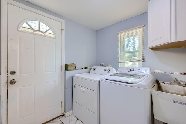 laundry area with cabinets, sink, a healthy amount of sunlight, and washing machine and clothes dryer