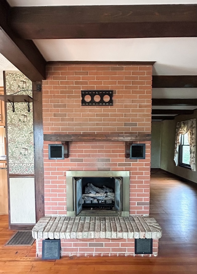 details with hardwood / wood-style flooring, a fireplace, and beamed ceiling