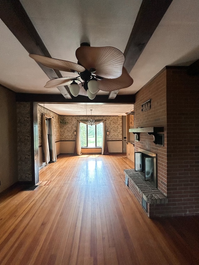 unfurnished living room with a brick fireplace, light hardwood / wood-style floors, and ceiling fan