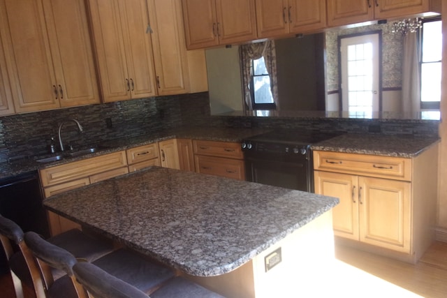 kitchen featuring decorative backsplash, sink, black electric range, kitchen peninsula, and a kitchen bar