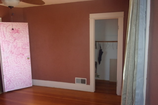 unfurnished bedroom featuring hardwood / wood-style flooring, ceiling fan, and a closet