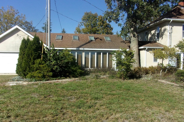 rear view of property featuring a lawn