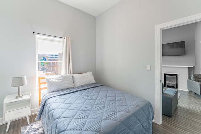 bedroom with a fireplace and hardwood / wood-style floors