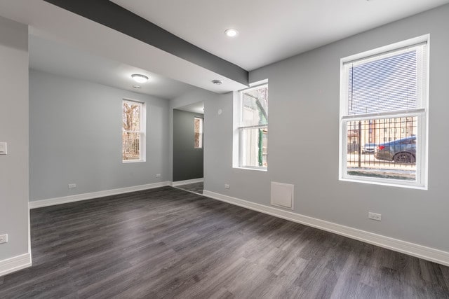 spare room with plenty of natural light and dark hardwood / wood-style floors