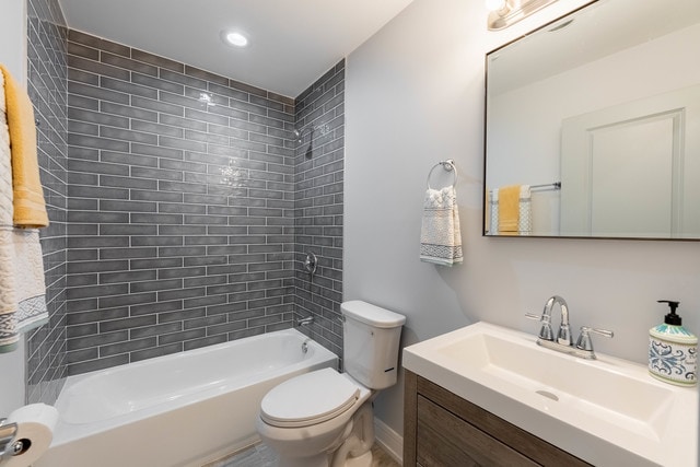 full bathroom with tiled shower / bath combo, vanity, and toilet